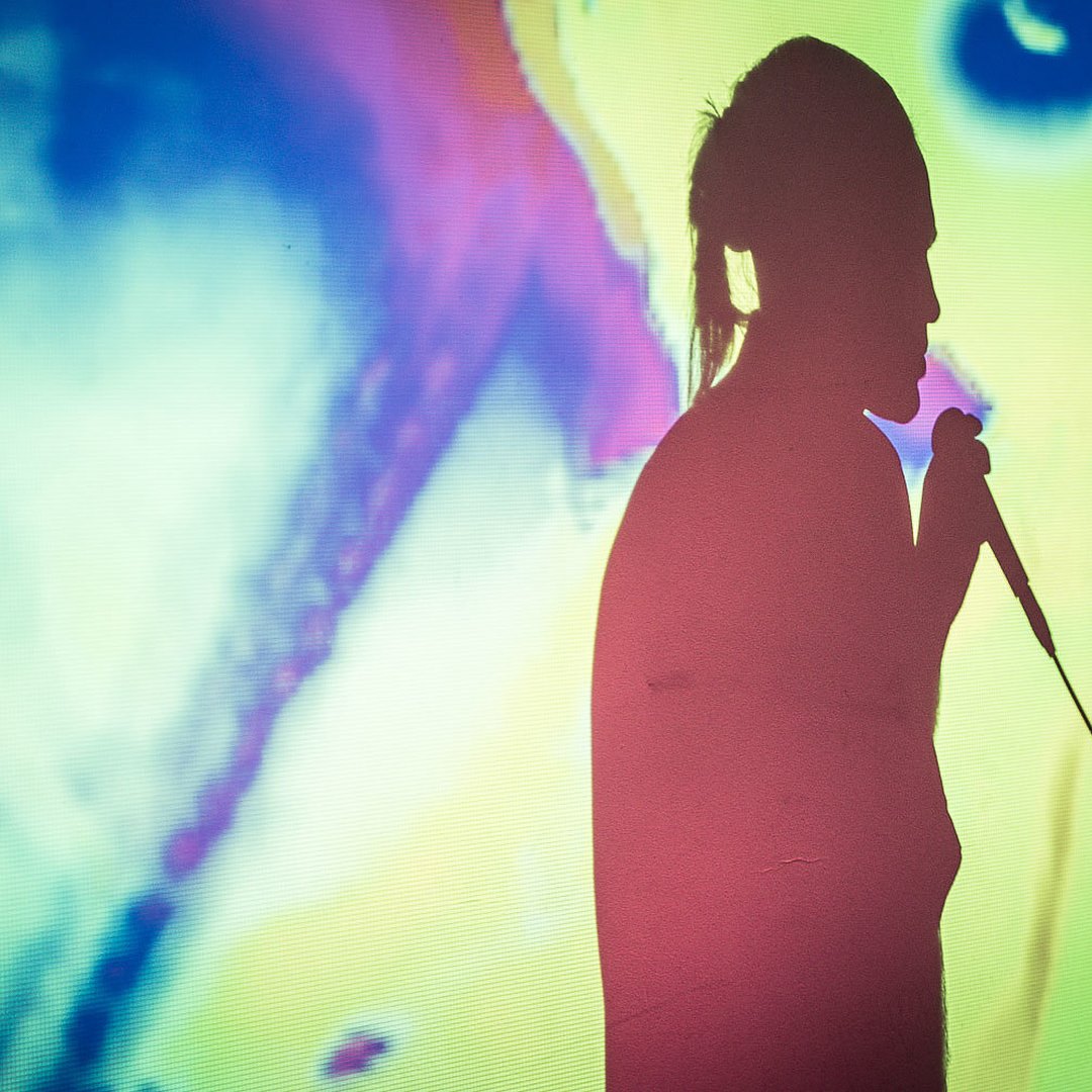 Silhouette of a singer against a colorful abstract background