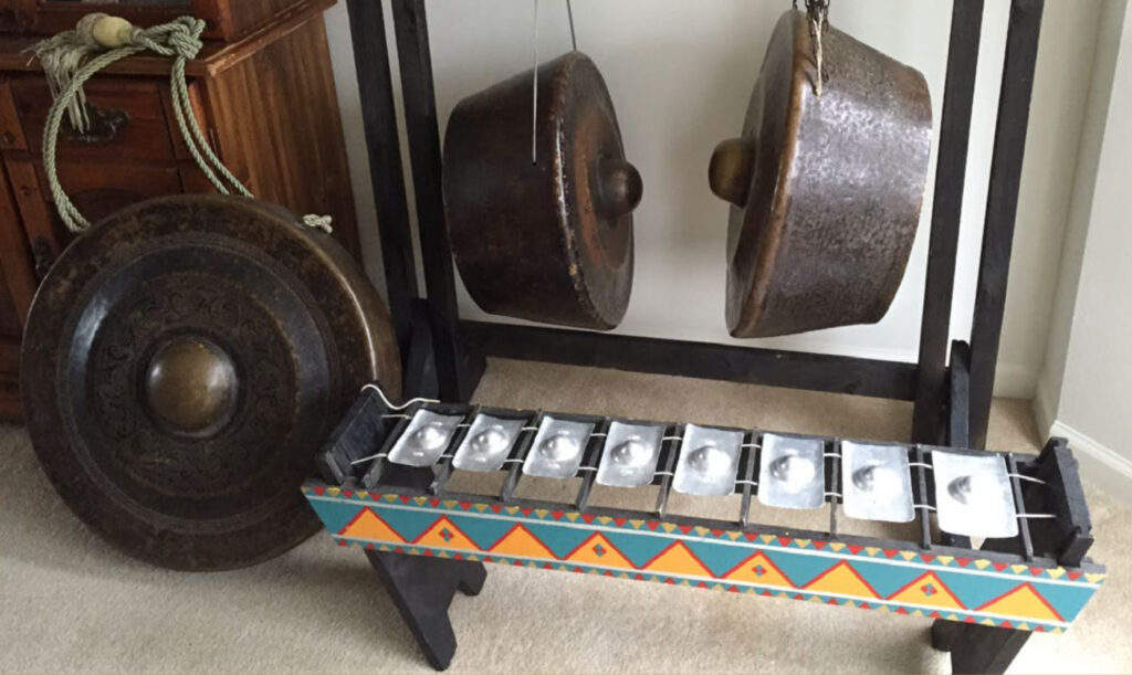 An instrument consisting of eight gong-like plates in front of three larger gongs.