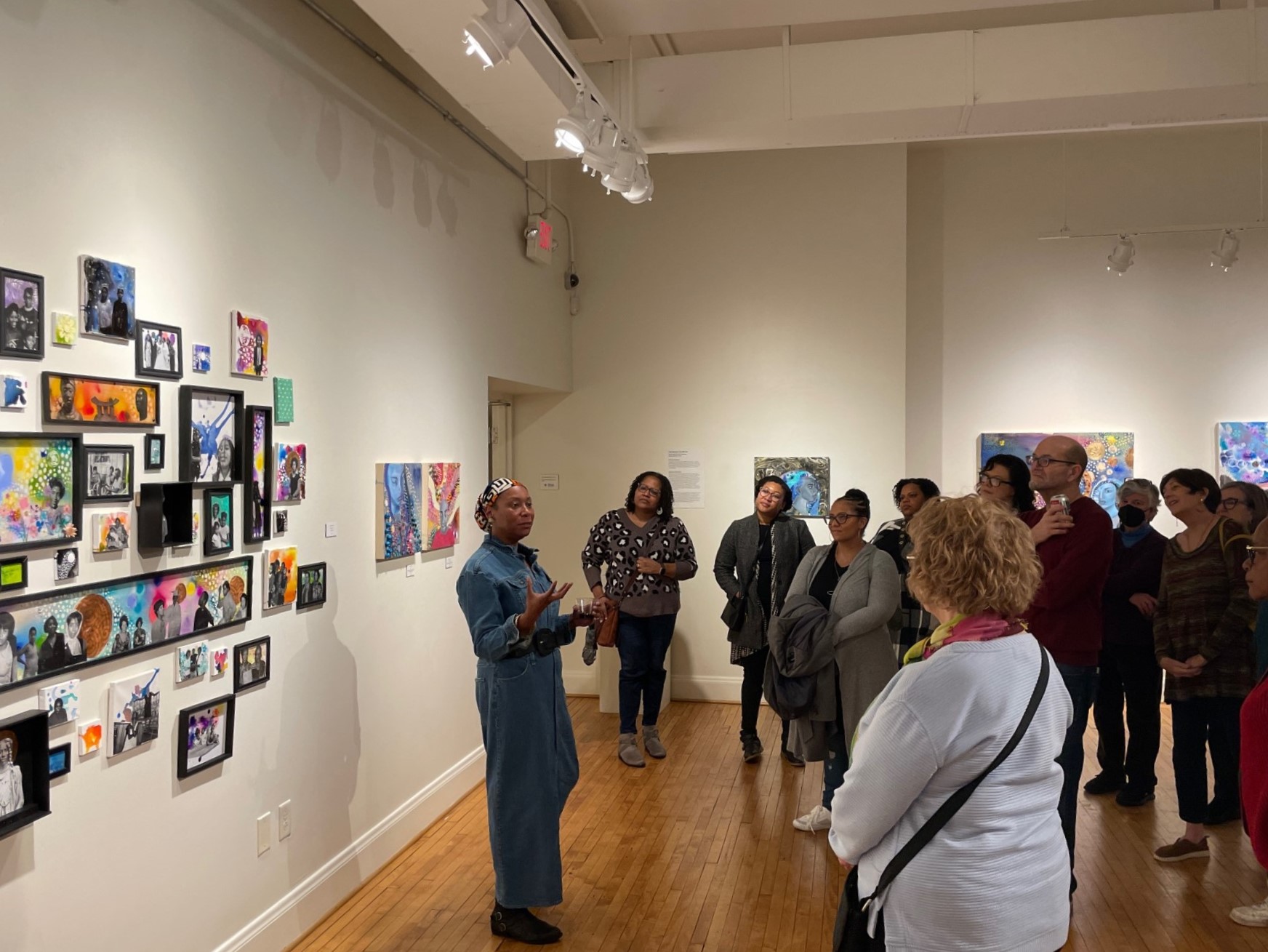 Artist speaks in a gallery to a gathered audience