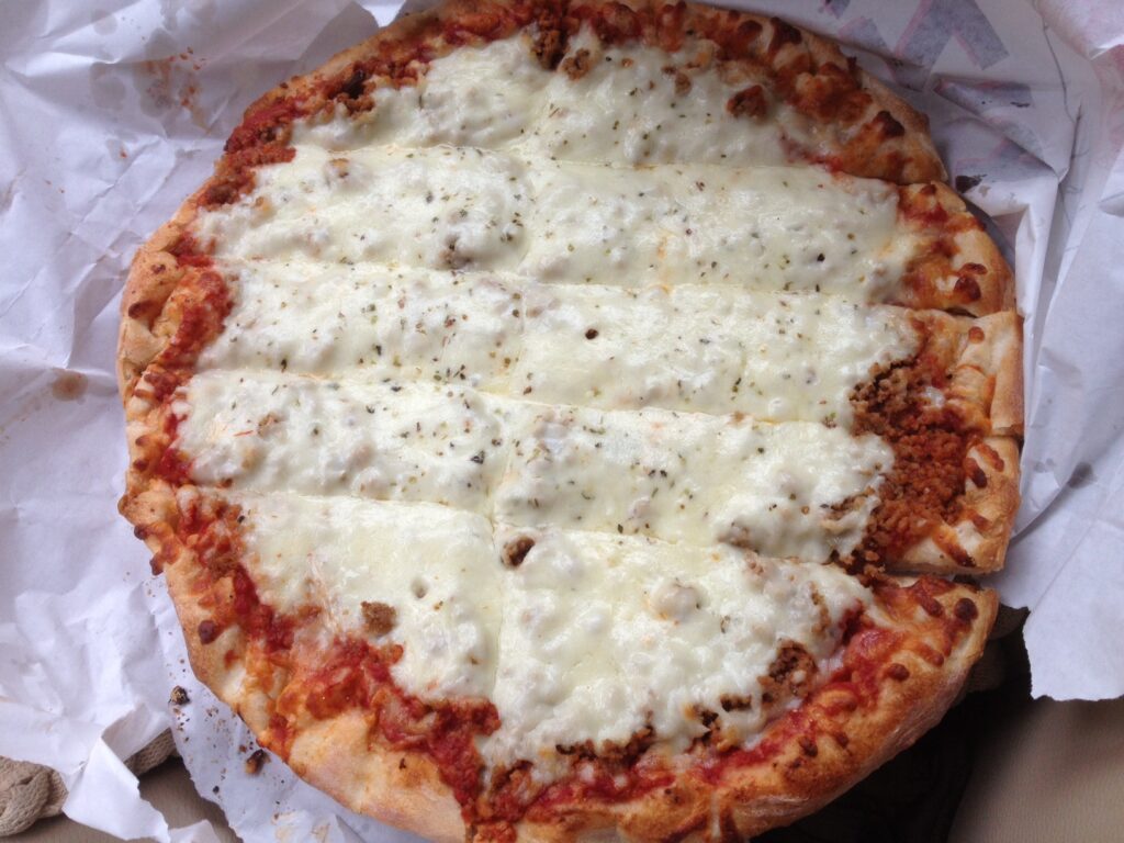 A circular pizza with a cheesy top.