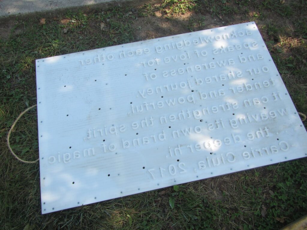 A white stamp with words on it lies in the grass.