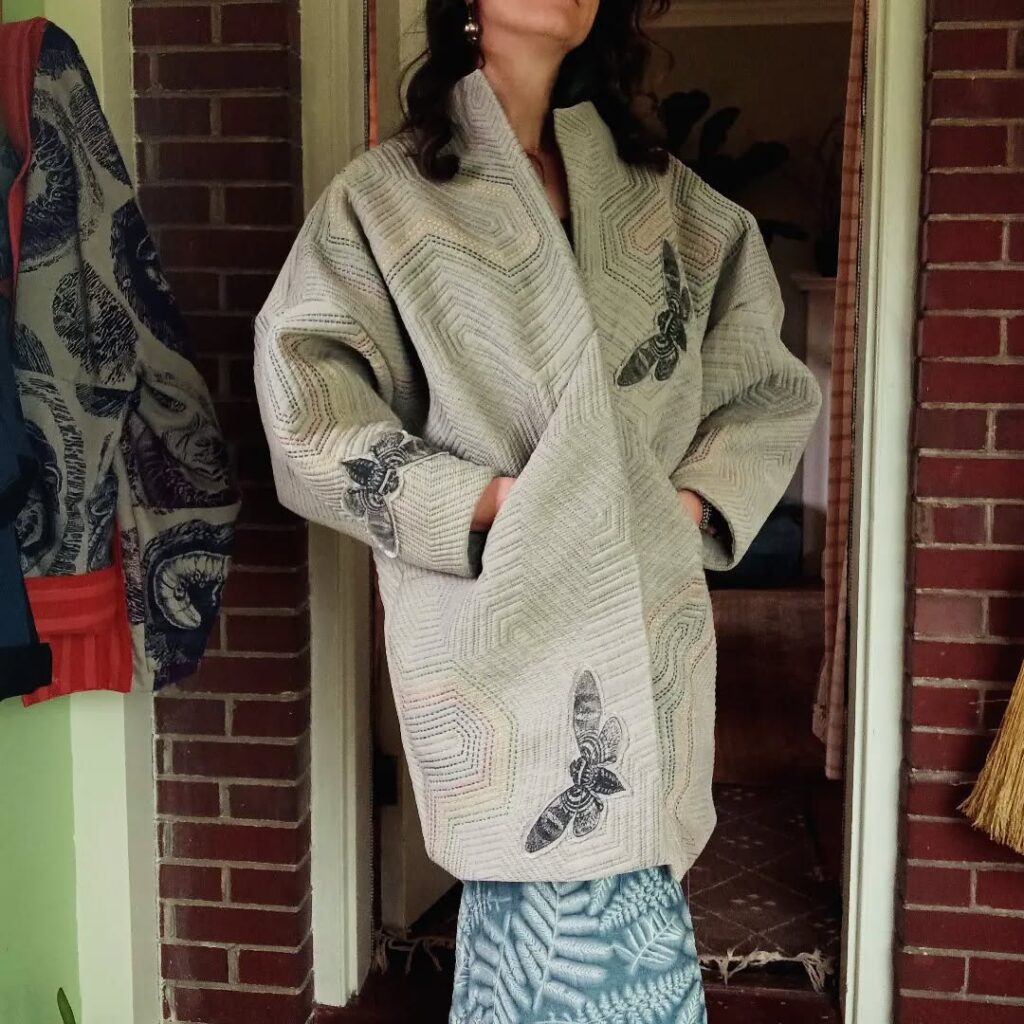 A person wearing a mid-length light colored coat.