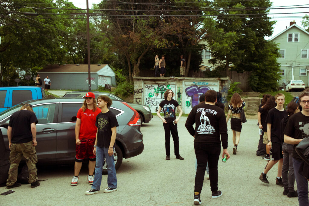 People standing around outside in a parking lot.