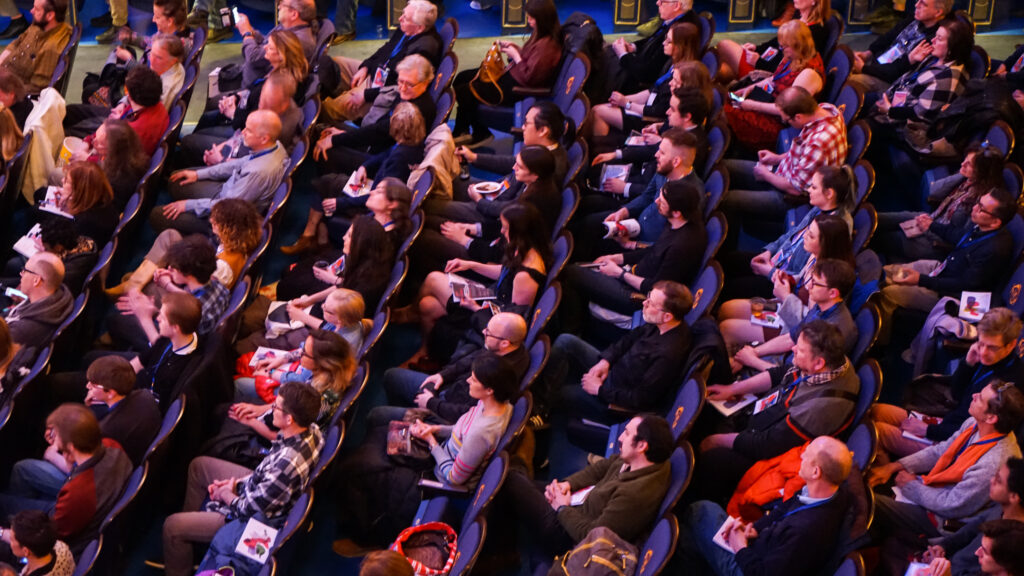People sitting in chairs in a theater.