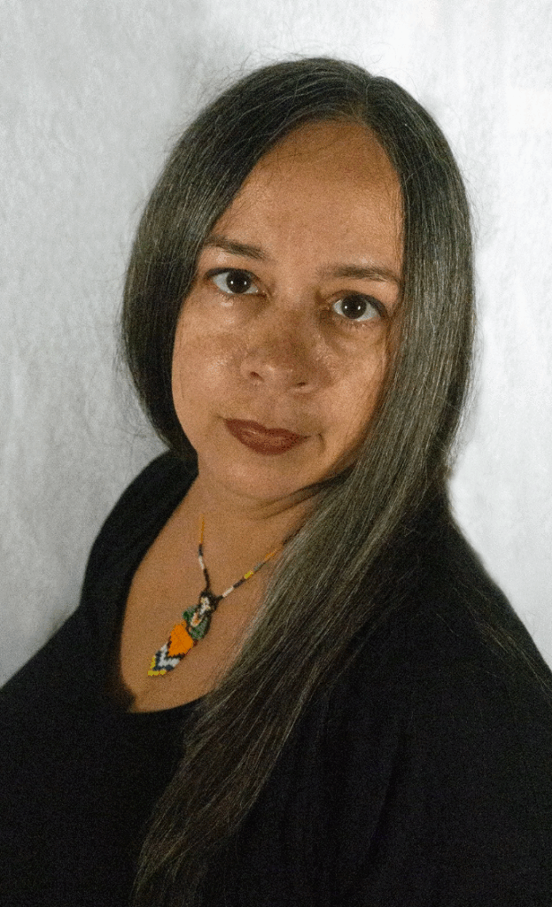 A portrait of a woman with medium skin tone wearing a black shirt and looking at the camera.