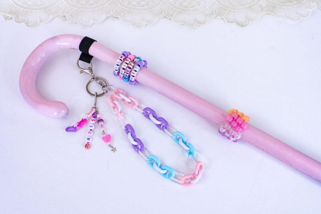 A pink cane with colorful beads.