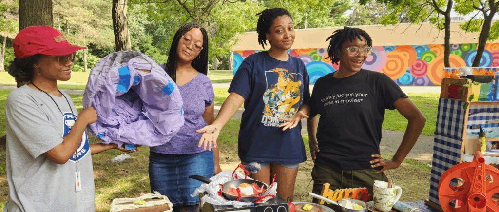 People stand around a table with art.