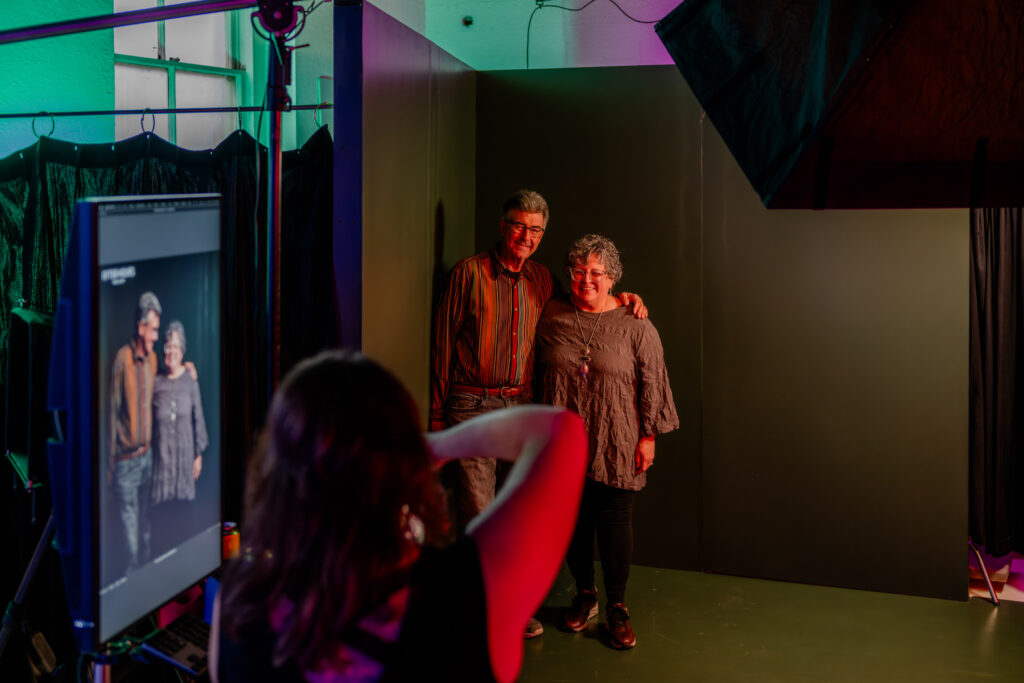 A person taking a photograph of two people.