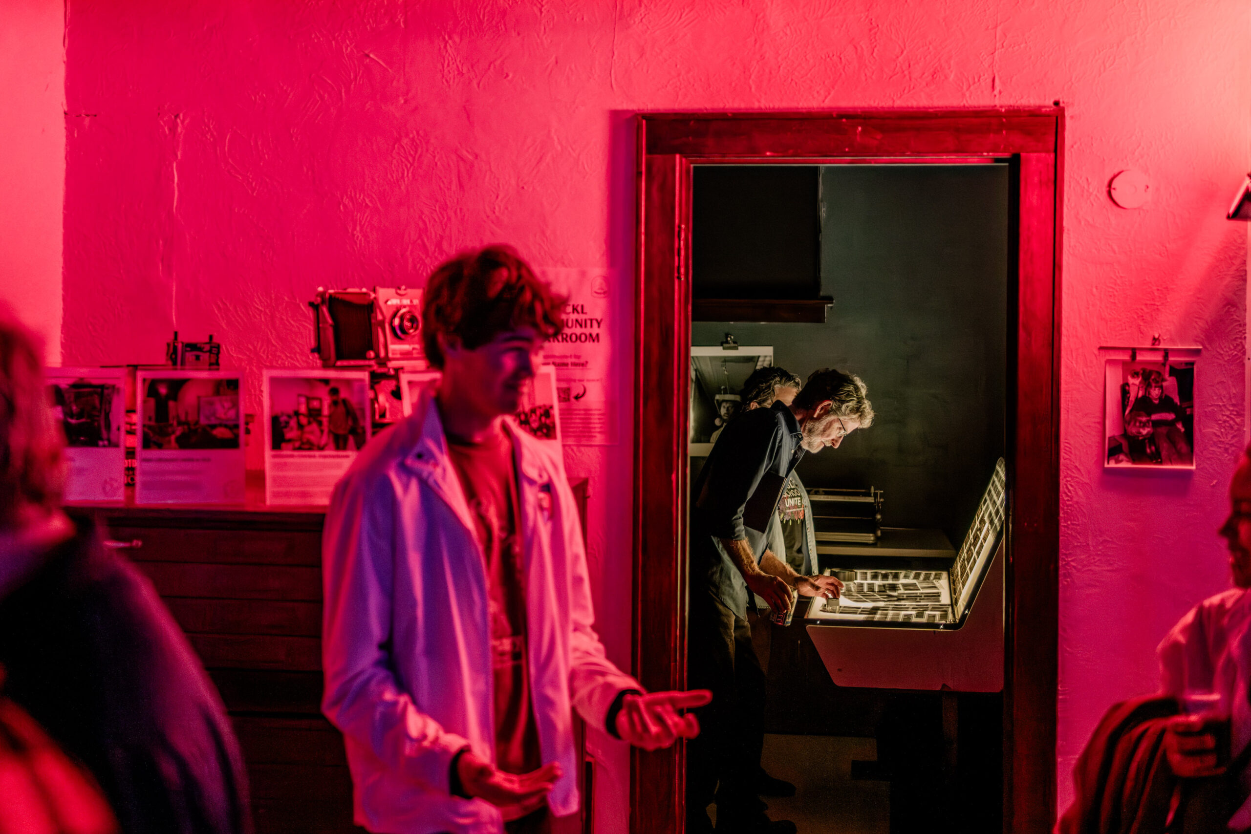 People in a darkroom with red light.