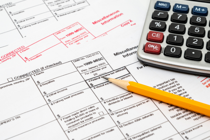 A pencil and a calculator on top of miscellaneous tax forms