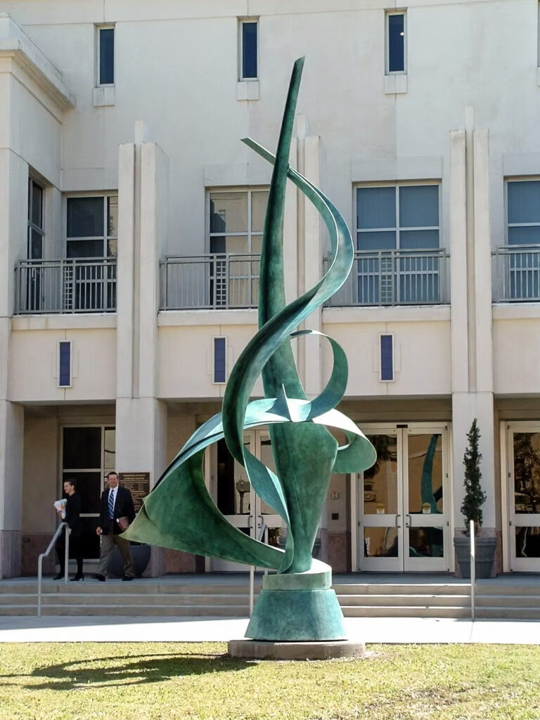 A spiral-like metal sculptural piece installed outdoors.