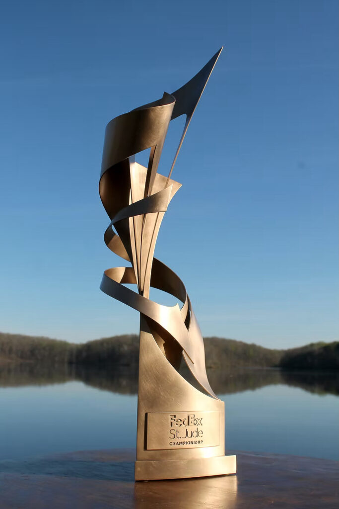 A bronze colored trophy with an abstract spiral-like design