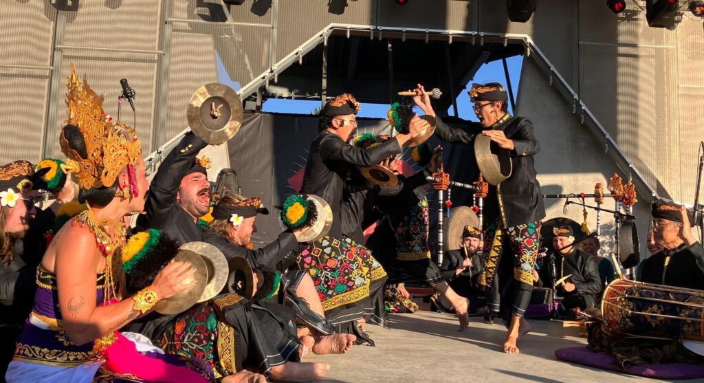 A group of performers during a Balinese gamelan playing different metal and percussive instruments