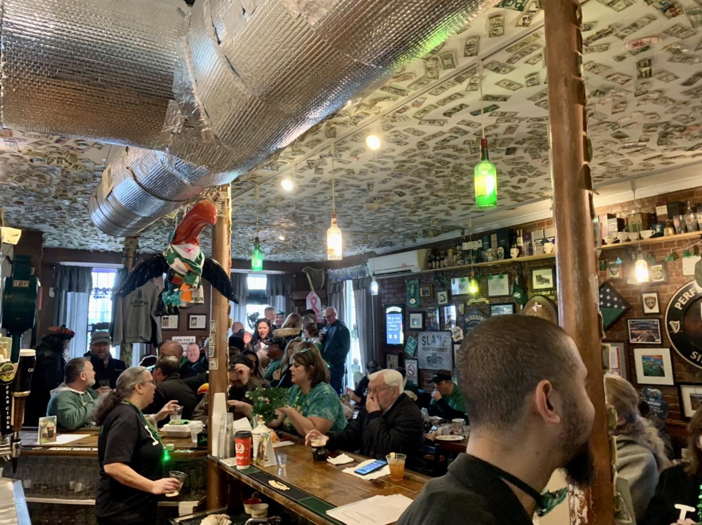 People serving patrons at a bar.