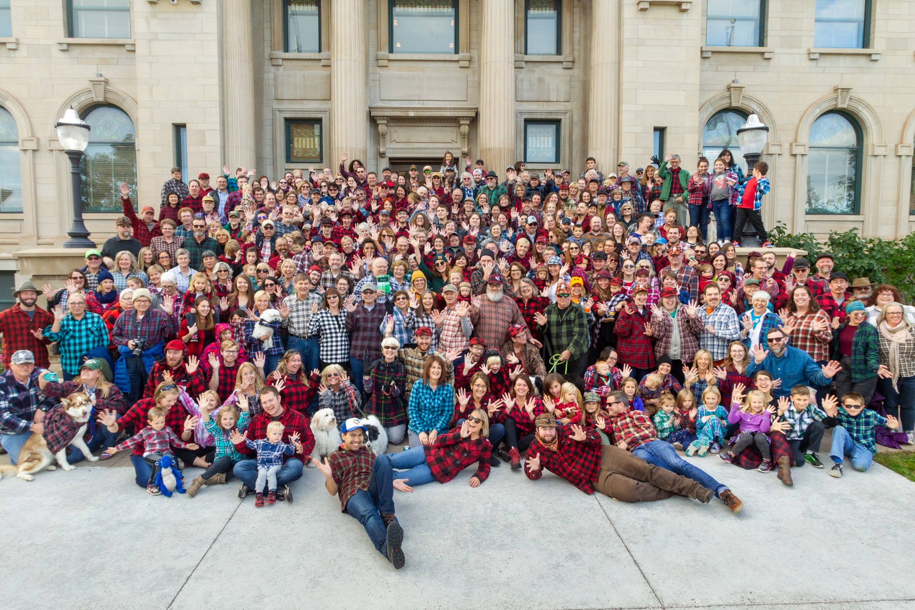 A large group of people all wearing plaid-patterned clothing posing together.
