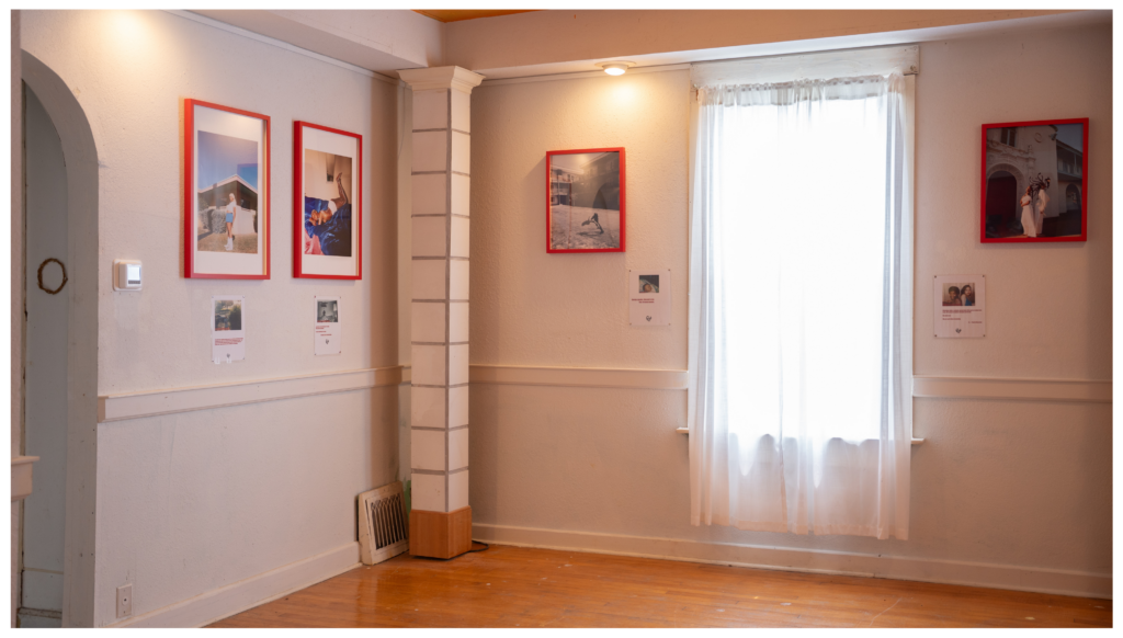 Artwork inside red frames inside a white, home-like gallery space.