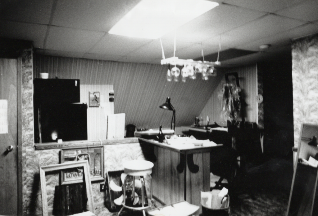 A black and white scene of a room filled with photo developing equipment.