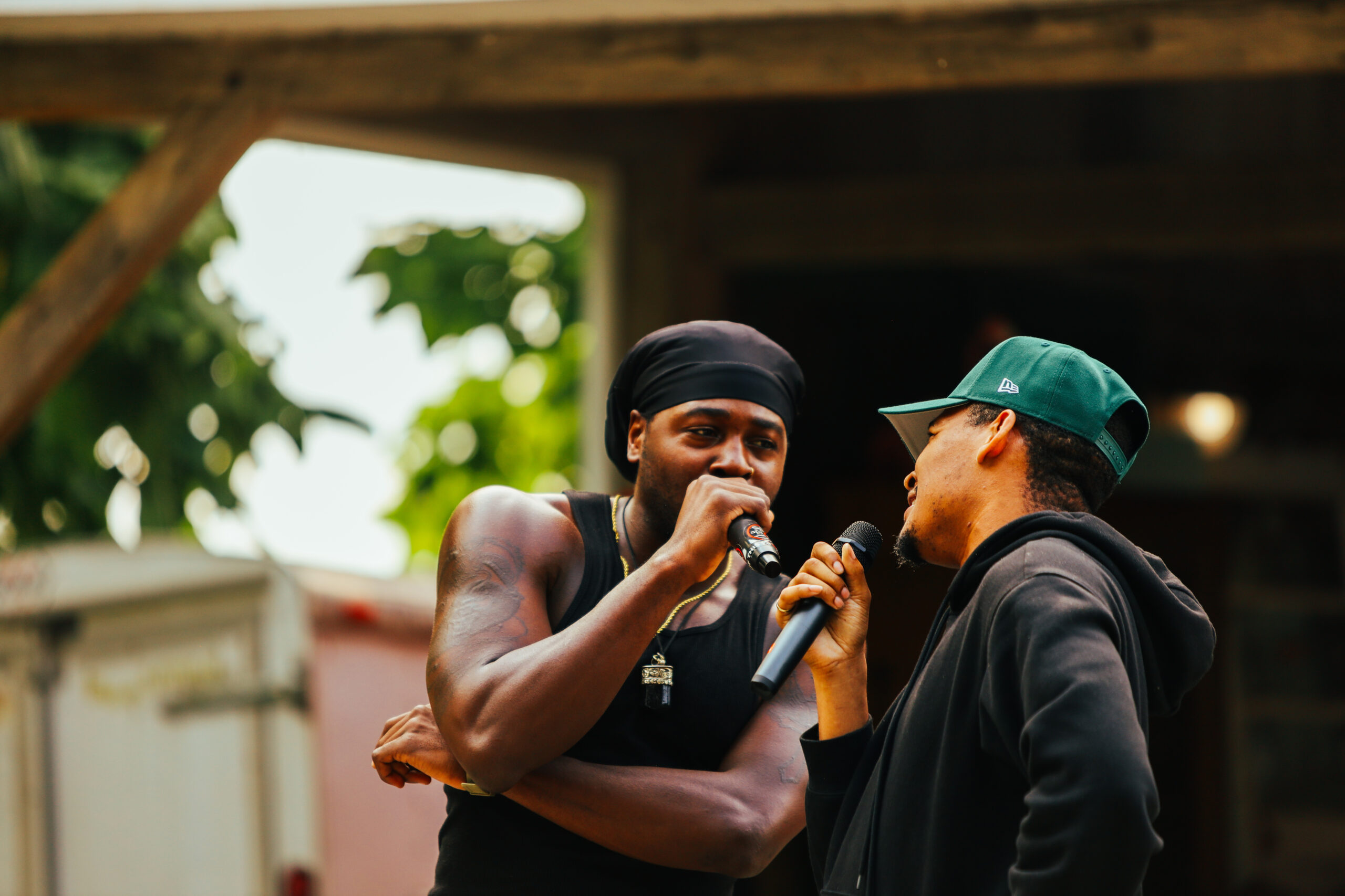 Two men holding microphones and rapping to each other.