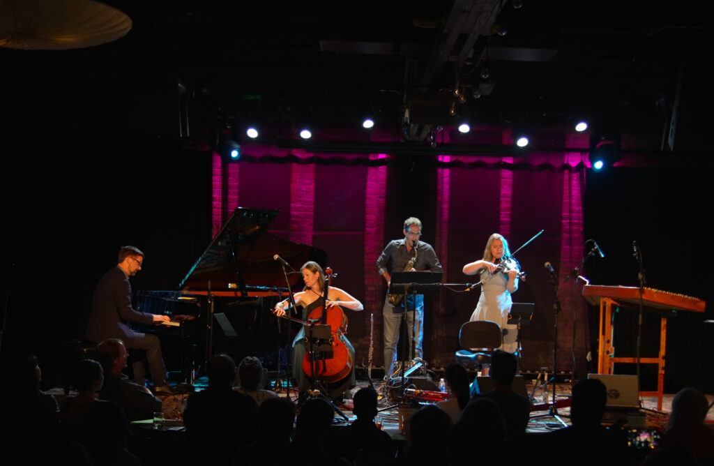 Four musicians playing on stage.