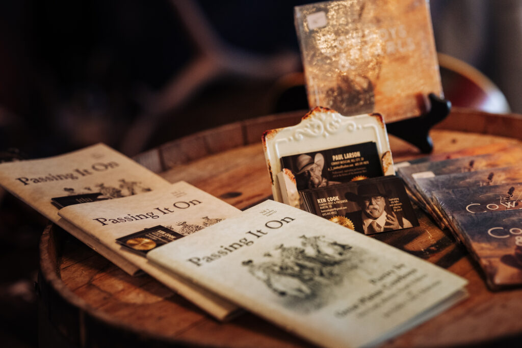 Small pamphlets are displayed on a table with the title "Passing it on" next to Ken Cook's business cards.