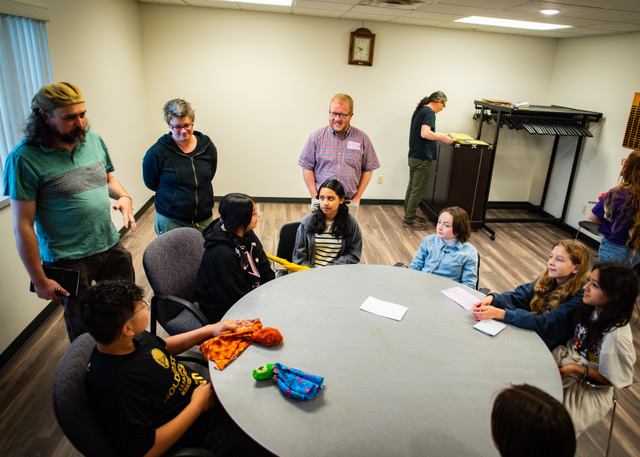 People gathered around a circle table indoors.