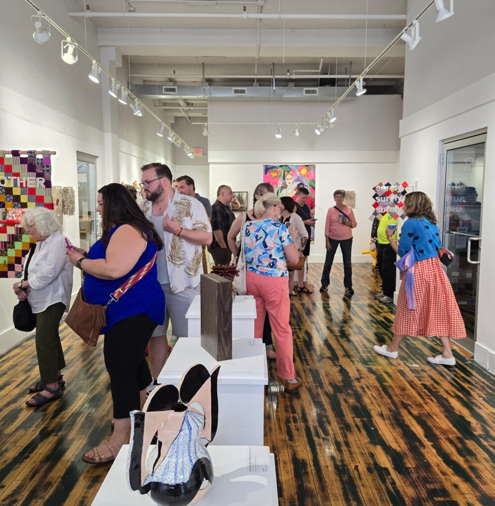 People scattered about an art gallery looking at art.